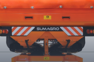 A powerful modern tractor mowing fields in a lush, sunny countryside, showcasing agricultural machinery at work.